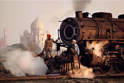 Operai su una locomotiva a vapore, India, 1983 Workers on a steam locomotive, India, 1983 ©Steve McCurry